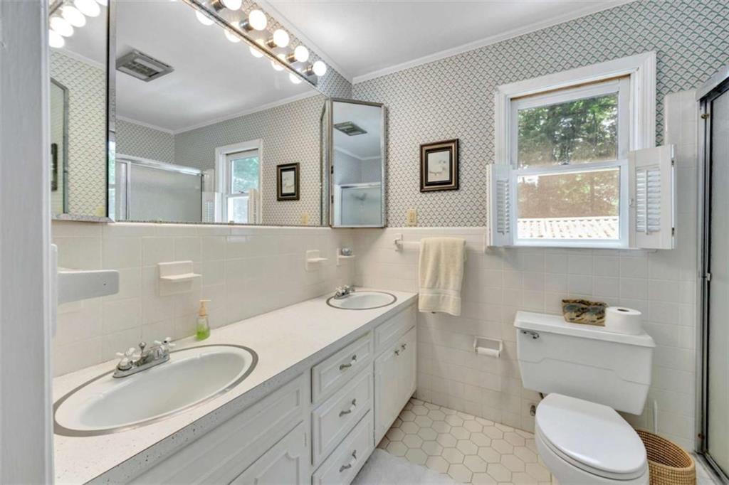 103 Gabriel Way Social Circle, GA 30025 - Photo 42 of 70 a bathroom with a toilet a sink a mirror a window and vanity