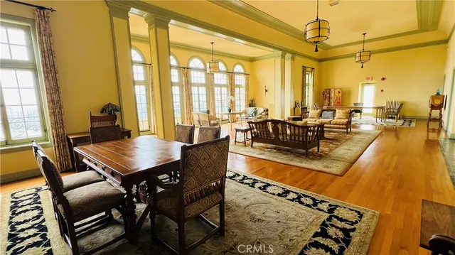 a living room with couches a dining table and chairs with wooden floor