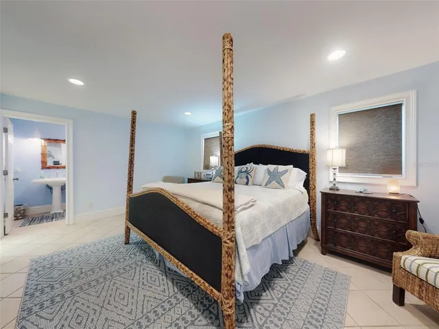 a large bedroom with a bed and wooden floor
