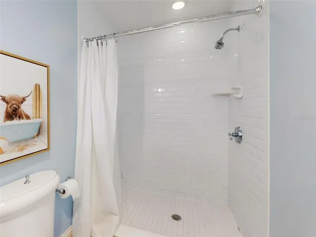 a bathroom with a shower a toilet and a shower