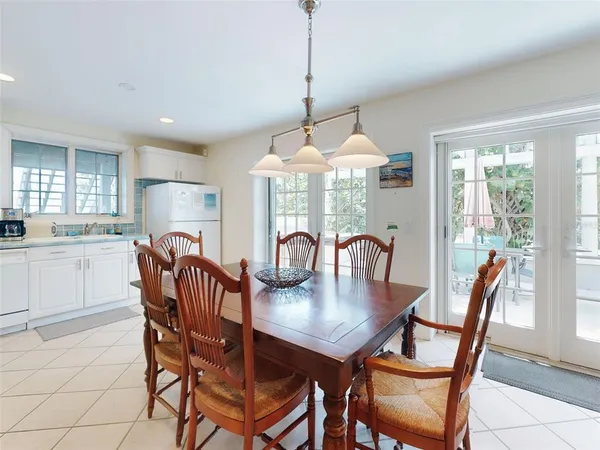 a dining room with furniture a chandelier and wooden floor