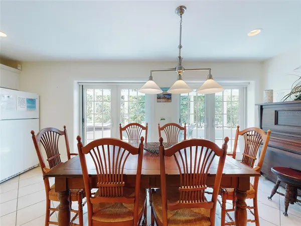 a dining room with furniture a chandelier and large windows
