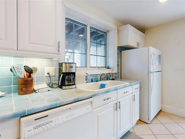 a kitchen with sink cabinets and refrigerator
