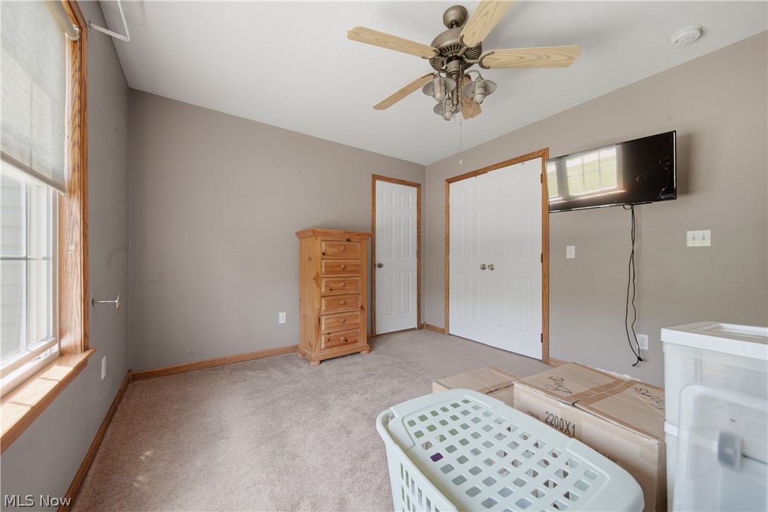 12159 Lawndell Road Southwest Beach City, OH 44608 - Photo 28 of 49 Angled ceiling room featuring a ceiling fan with integrated lighting, wood-finish window trim, and carpet flooring