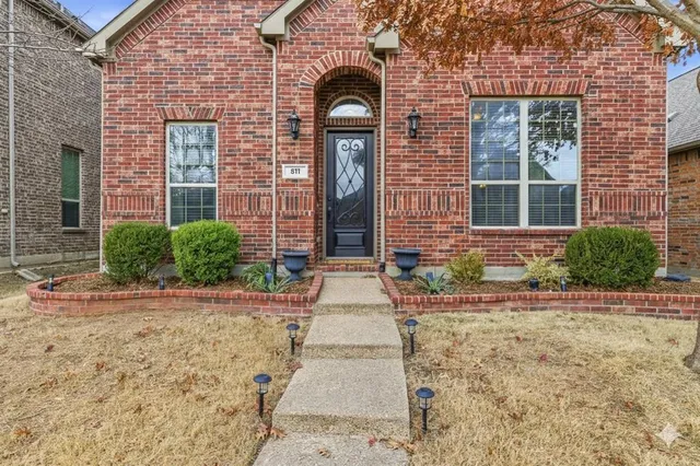 front view of a brick house with a small yard