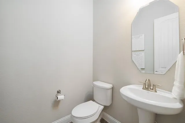 a bathroom with a toilet a sink and mirror