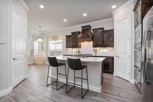 a kitchen with granite countertop a refrigerator and wooden cabinets