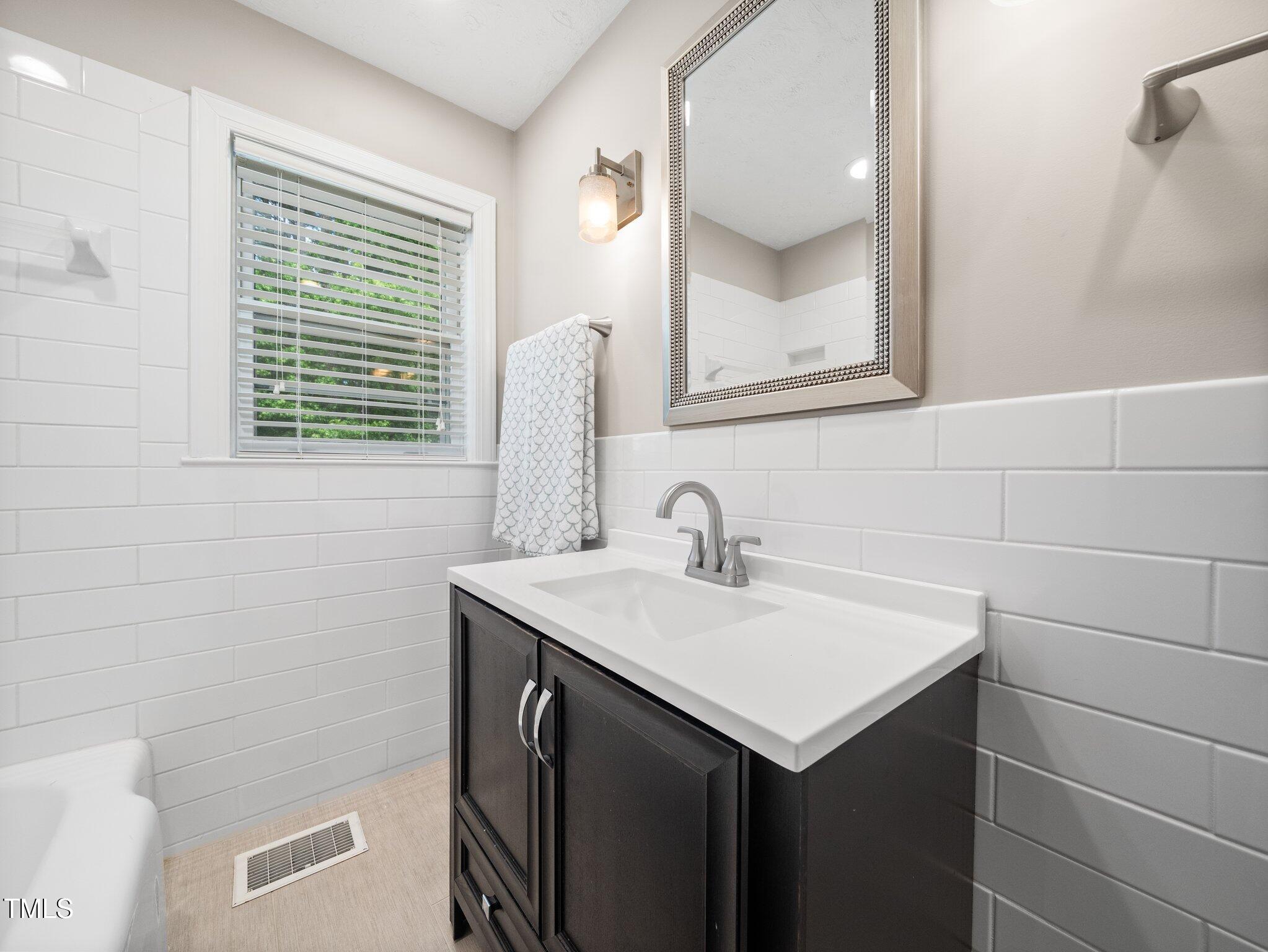 1313 Ridge Road Raleigh, NC 27607 - Photo 21 of 37 a bathroom with a sink and a mirror