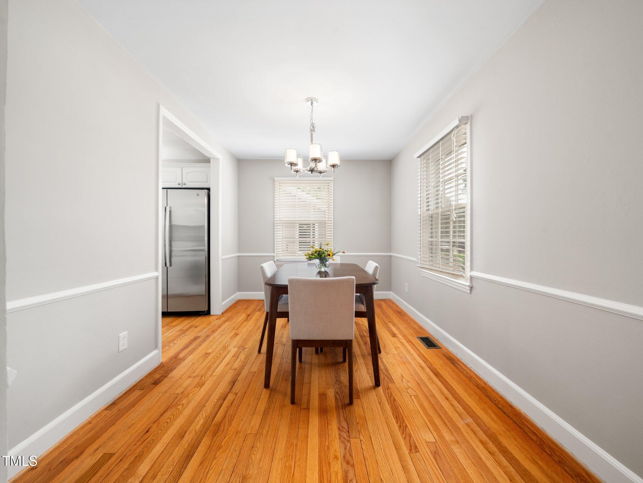 1313 Ridge Road Raleigh, NC 27607 - Photo 10 of 37 a dining room with wooden floor and a chandelier