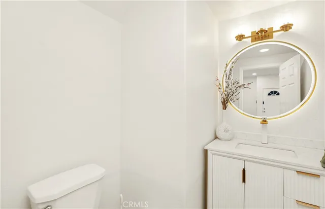 a bathroom with a sink mirror and toilet