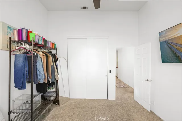 a view of walk in closet with clothes and shoes