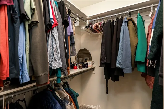 a view of walk in closet with clothes
