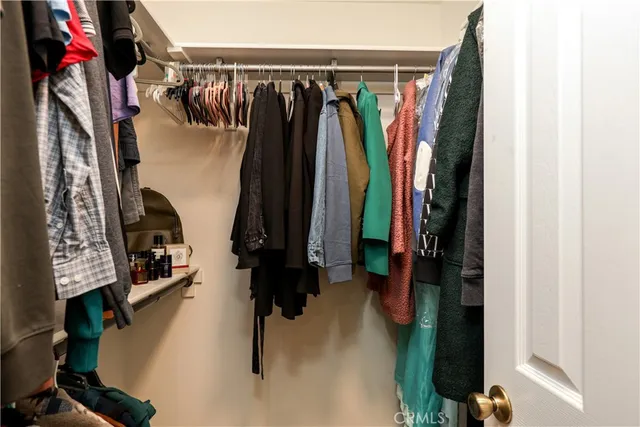 a view of walk in closet with clothes and shoes