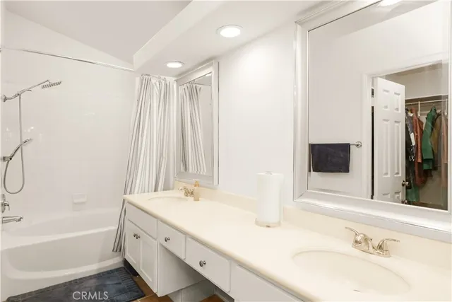 a bathroom with a tub sink and mirror
