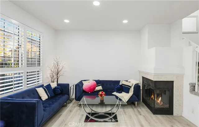 a living room with furniture a fireplace and a floor to ceiling window