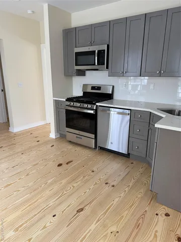 a kitchen with granite countertop a stove and a microwave