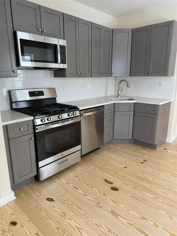 a kitchen with stainless steel appliances granite countertop a stove a microwave and a sink