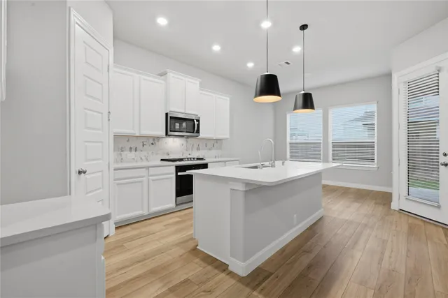 a kitchen with a sink stove and cabinets