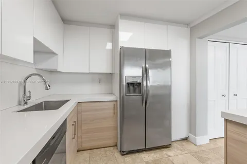 a kitchen with a refrigerator sink and cabinets