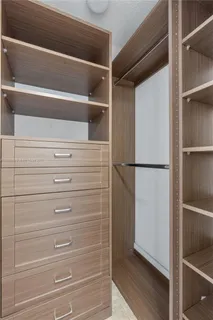 a view of walk in closet with empty racks