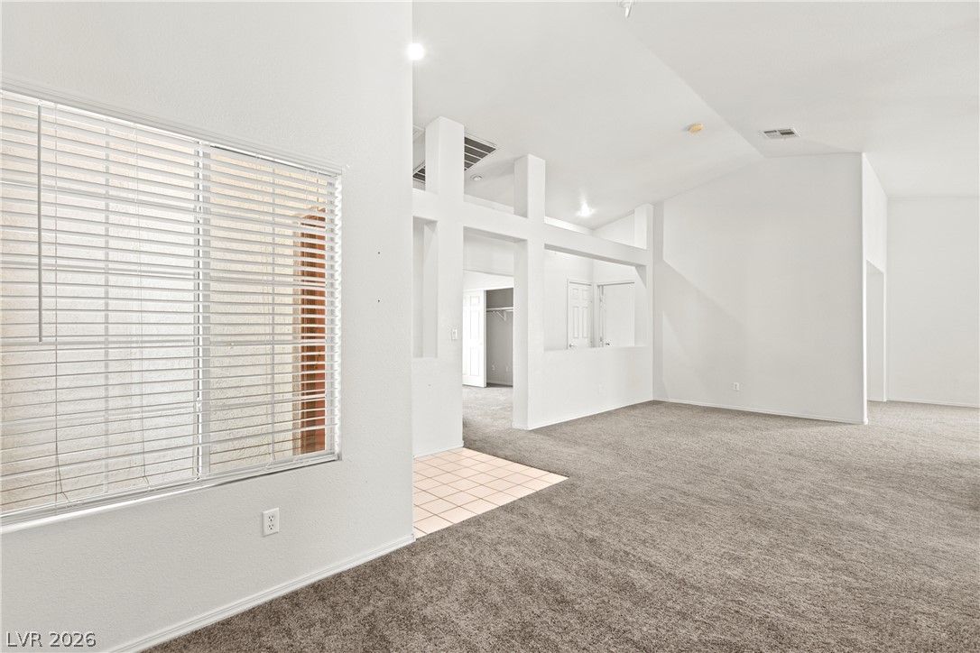 1815 Stablegate Avenue Henderson, NV 89012 - Photo 2 of 28 A spacious living room features vaulted ceilings, providing an airy and open atmosphere.