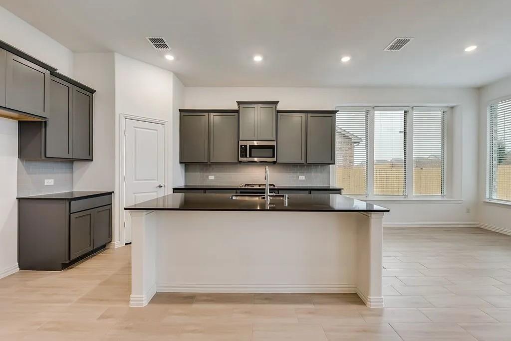 3900 Falcon Field Mesquite, TX 75181 - Photo 4 of 12 a large kitchen with a large counter top stainless steel appliances and cabinets