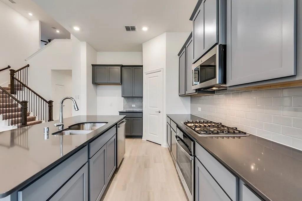 3900 Falcon Field Mesquite, TX 75181 - Photo 6 of 12 a kitchen with stainless steel appliances granite countertop a sink a stove and a refrigerator