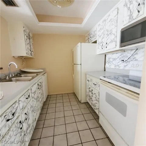 a view of a livingroom with wooden floor and a refrigerator