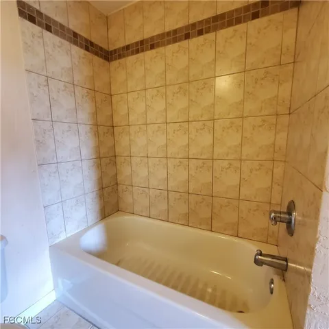 a bath tub sitting next to a blue sink and a shower