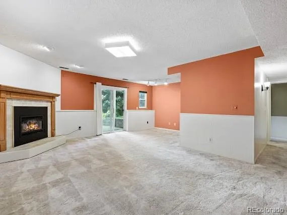 a view of an empty room with a fireplace and a window