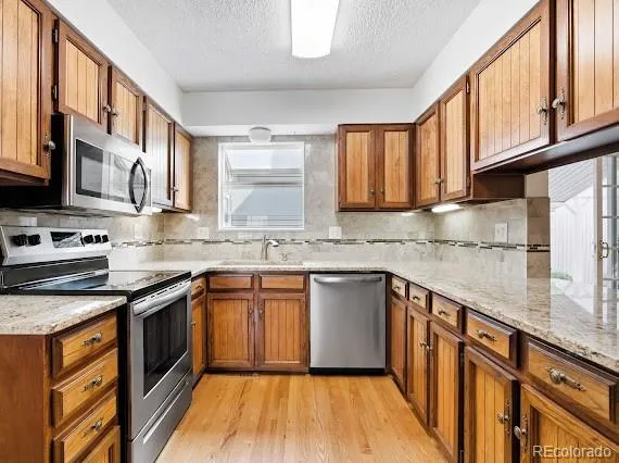 a kitchen with stainless steel appliances granite countertop a stove a sink and a granite counter tops