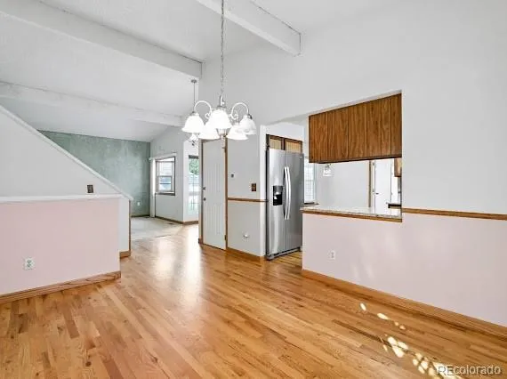 a view of a refrigerator in kitchen and wooden floor
