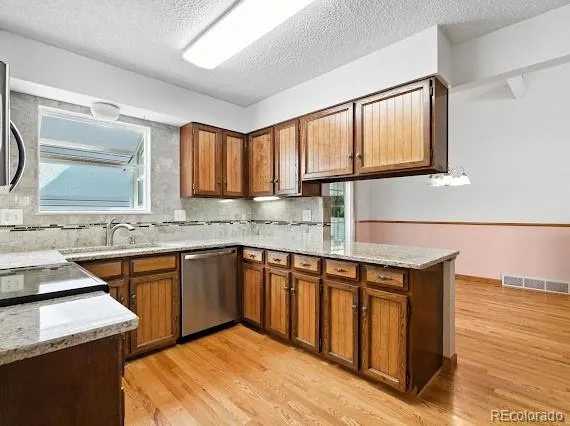 a kitchen with stainless steel appliances granite countertop a sink stove and cabinets