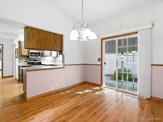 a kitchen with kitchen island granite countertop a stove top oven a sink with wooden floor and cabinets