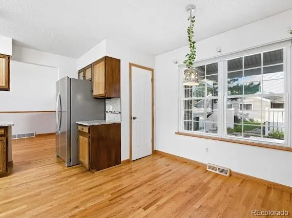 a view of a kitchen with wooden floor and a window