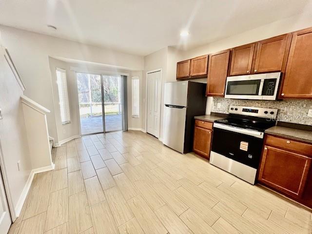 15633 Stable Run Drive Spring Hill, FL 34610 - Photo 14 of 50 a kitchen with stainless steel appliances a stove a refrigerator a sink a microwave a counter top space and cabinets