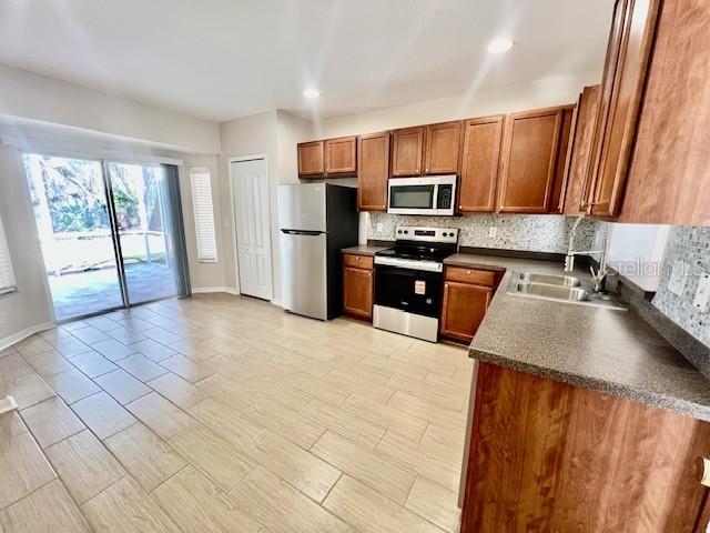 15633 Stable Run Drive Spring Hill, FL 34610 - Photo 15 of 50 a kitchen with stainless steel appliances granite countertop a stove a sink and a microwave