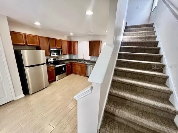 a view of kitchen with sink and refrigerator