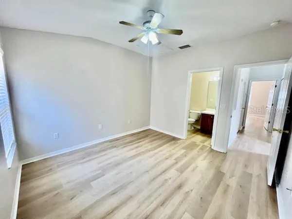 an empty room with wooden floor and window