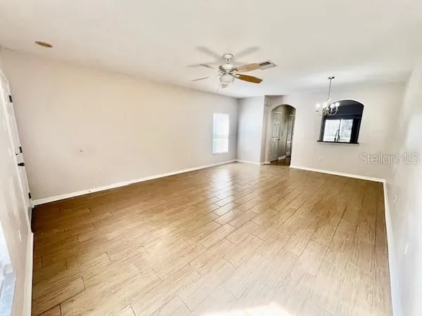 a view of a livingroom with wooden floor and a ceiling fan