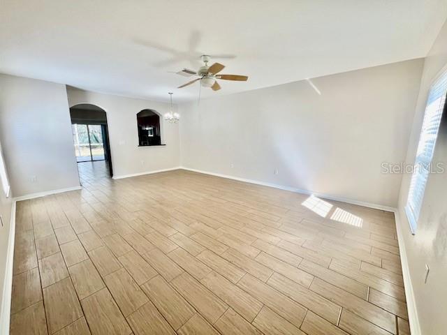 15633 Stable Run Drive Spring Hill, FL 34610 - Photo 8 of 50 an empty room with wooden floor ceiling fan and windows