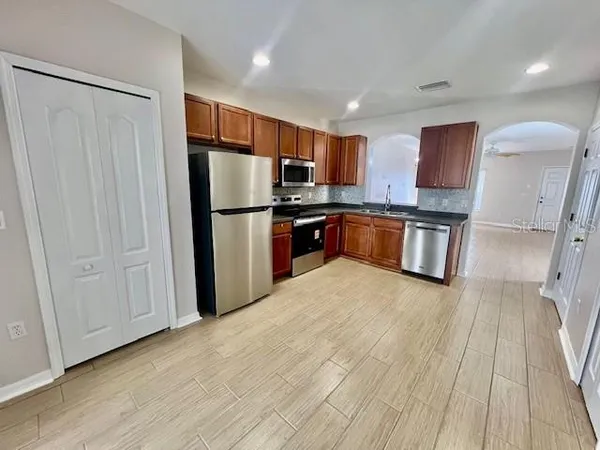 a kitchen with stainless steel appliances granite countertop a refrigerator stove top oven and sink