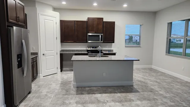 a view of a kitchen with stainless steel appliances granite countertop a refrigerator and a sink