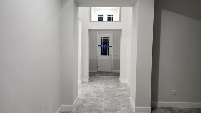 a view of a hallway with wooden floor and a bathroom