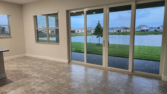a view of an empty room with a floor to ceiling window and lake view