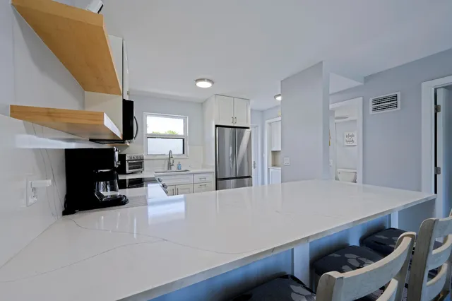 a bathroom with a granite countertop toilet sink and mirror