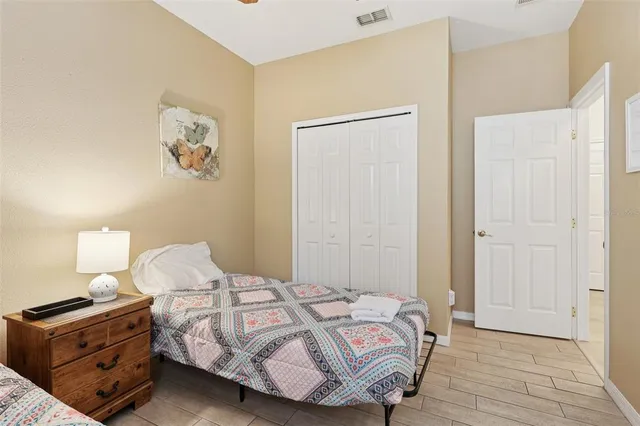 a bedroom with a bed and a lamp on dresser