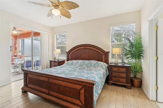a bedroom with a bed and a large mirror on the dresser with wooden floor