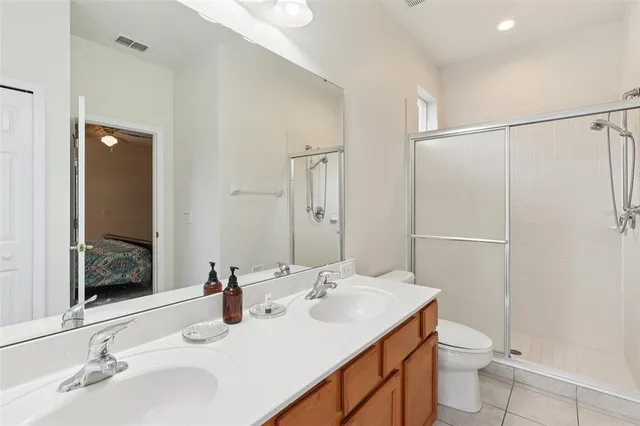 a bathroom with a double vanity sink toilet and a mirror