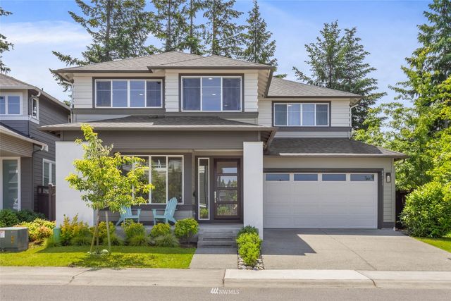 a front view of a house with a garden and plants